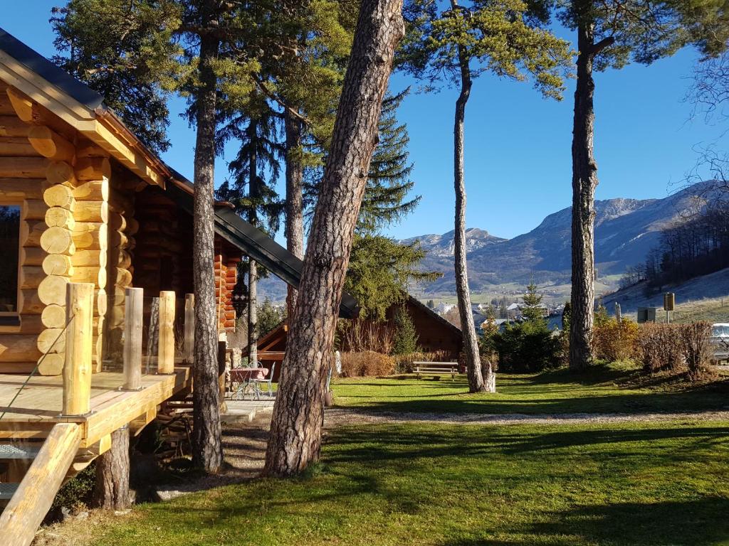 a log cabin with mountains in the background at Magnifique chalet en rondins avec sauna - Vercors in Villard-de-Lans
