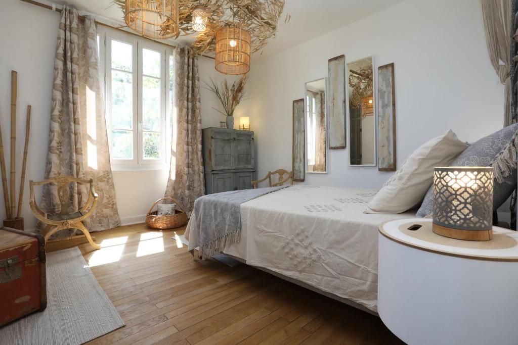 a bedroom with a bed and some windows at Demeure Urbaine in Romans-sur-Isère