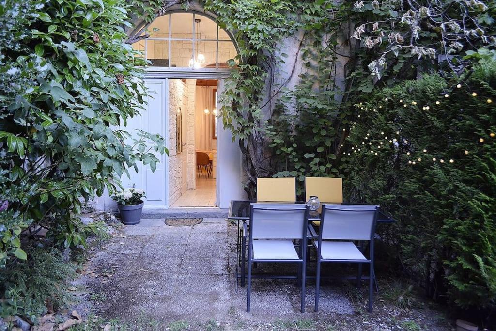 una mesa y sillas sentadas frente a una puerta en Le Chateau, en Évian-les-Bains