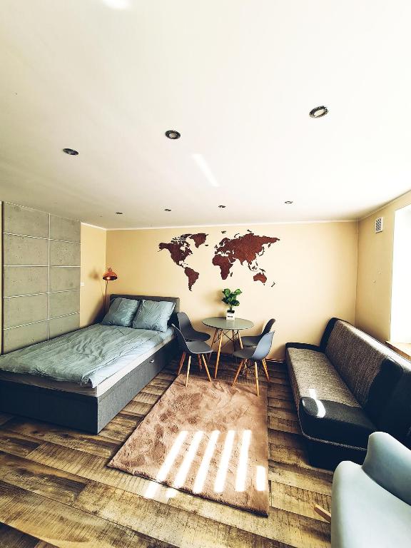 sypialnia z łóżkiem, stołem i kanapą w obiekcie Apartamencik Nad Jeziorem Dzwon Marcinkowo 51 - 2 w mieście Mrągowo