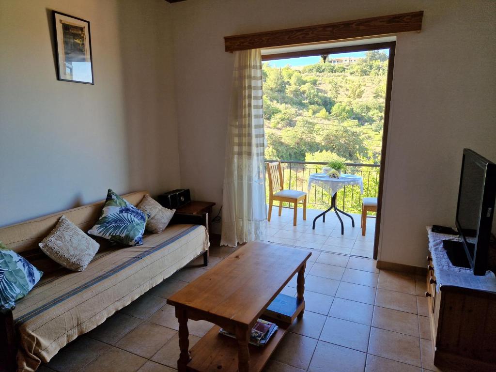 a living room with a couch and a table at Arsos Village Apartment in Arsos