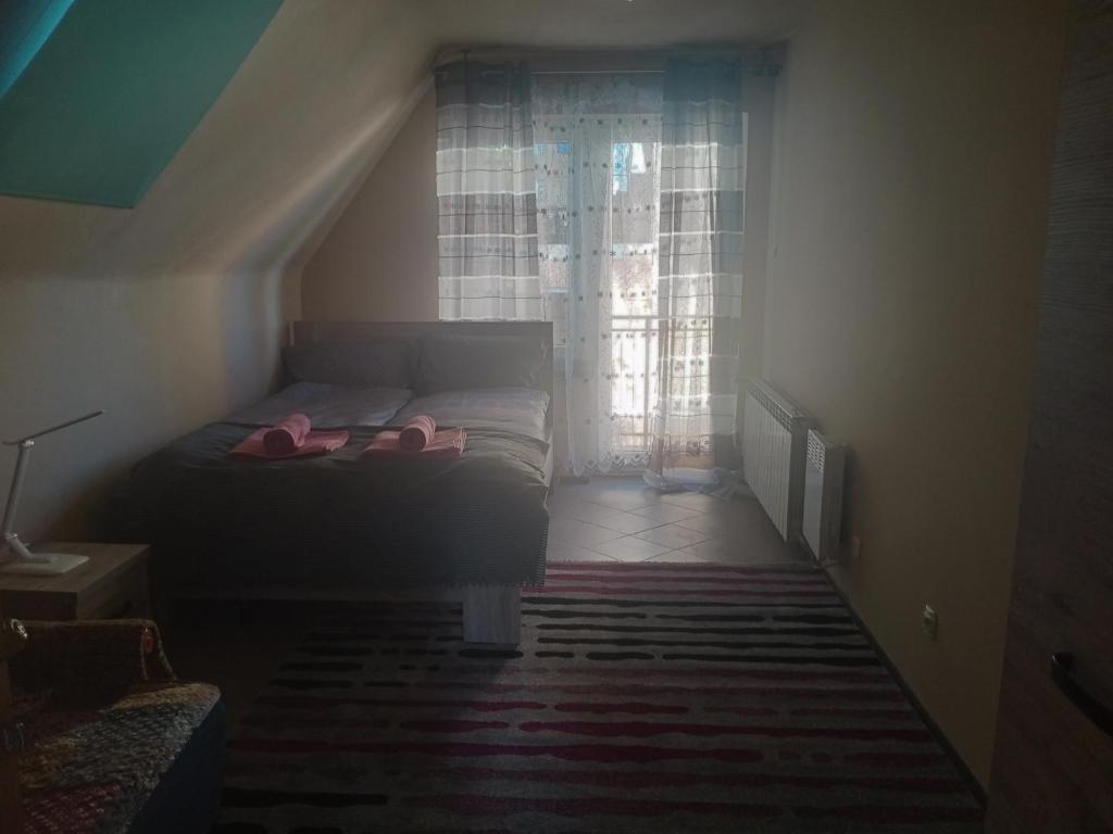 Un dormitorio con una cama con zapatillas rosas. en Uroczy apartament, en Cracovia