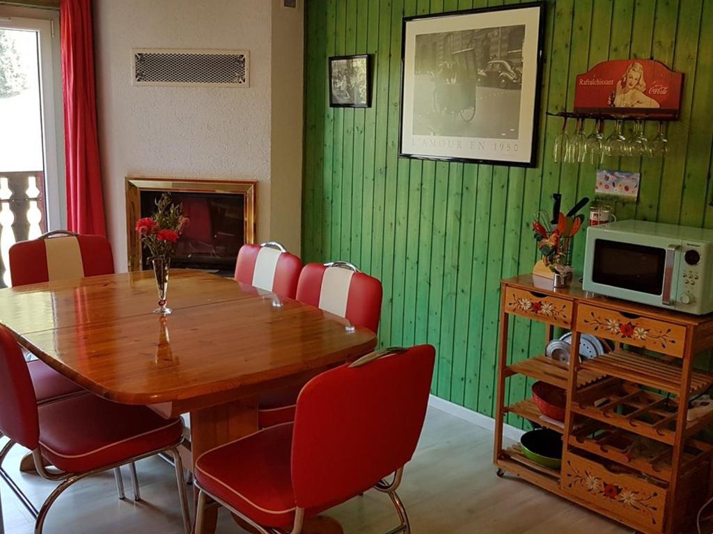 a dining room with a wooden table and red chairs at Appartement Le Biot, 3 pièces, 6 personnes - FR-1-573-41 in Bonnevaux