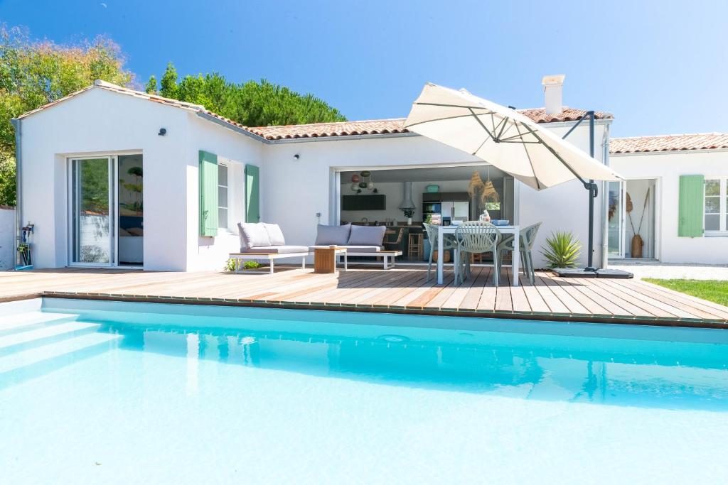 een villa met een zwembad en een huis bij Magnifique Récente Villa de charme avec piscine in Le Bois-Plage-en-Ré