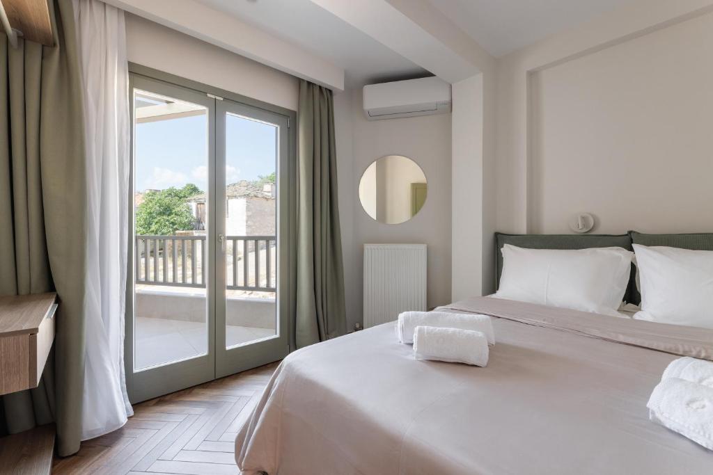 1 dormitorio con cama grande y ventana grande en Helia All Seasons Apartments, en Astris