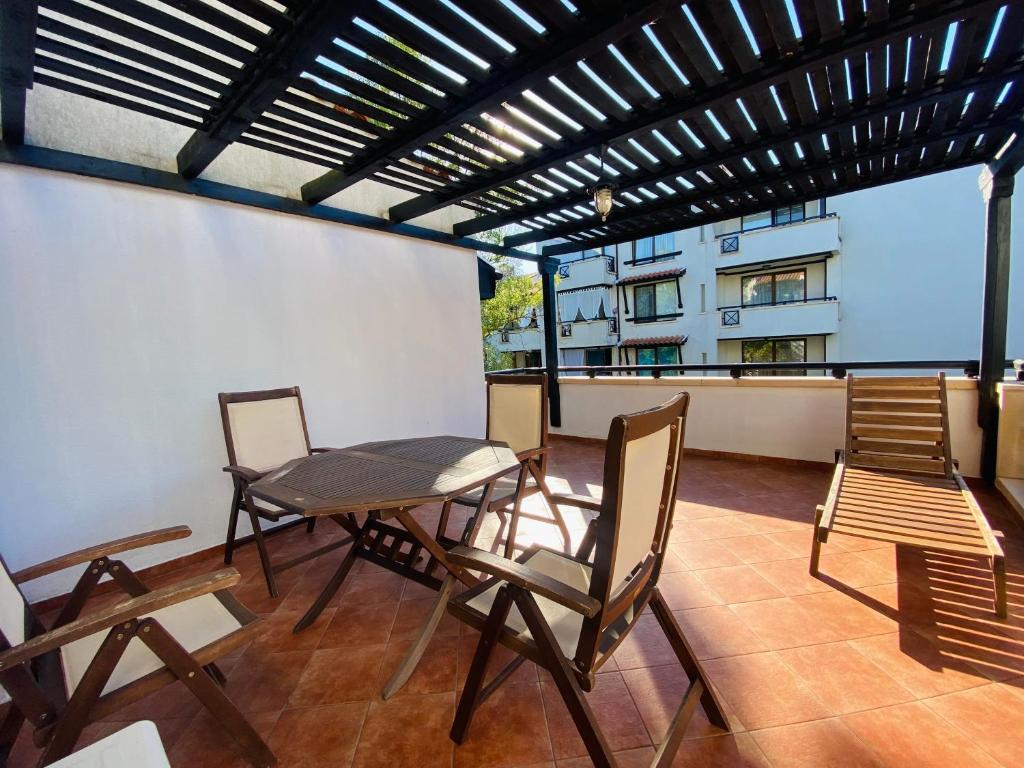 a balcony with a table and chairs and a building at La Terraza del Oasis in Lozenets