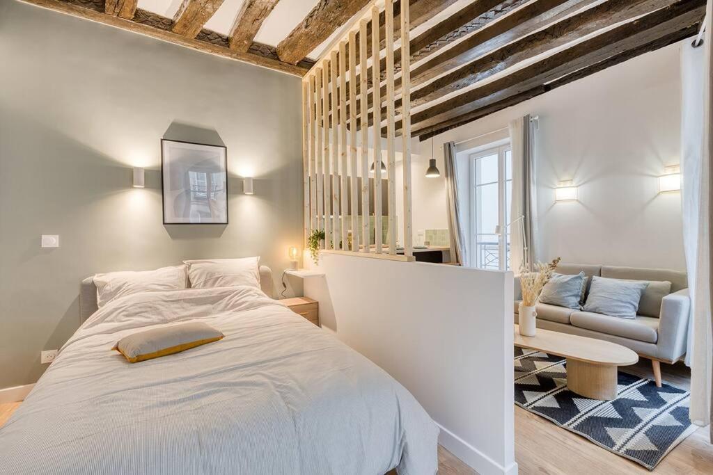 une chambre avec un grand lit blanc et un canapé dans l'établissement GemBnB Luxury Apartments - Résidence Villedo, à Paris