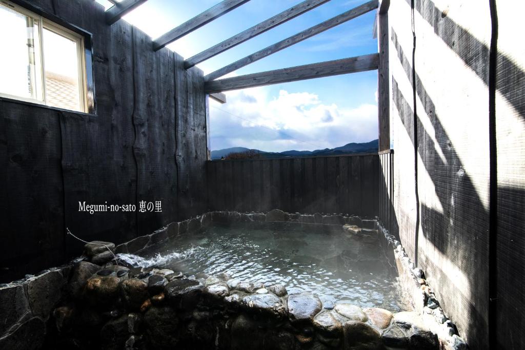 a pool of water in a building with a window at Yufuin Yukari-an Megumi no Sato in Yufuin