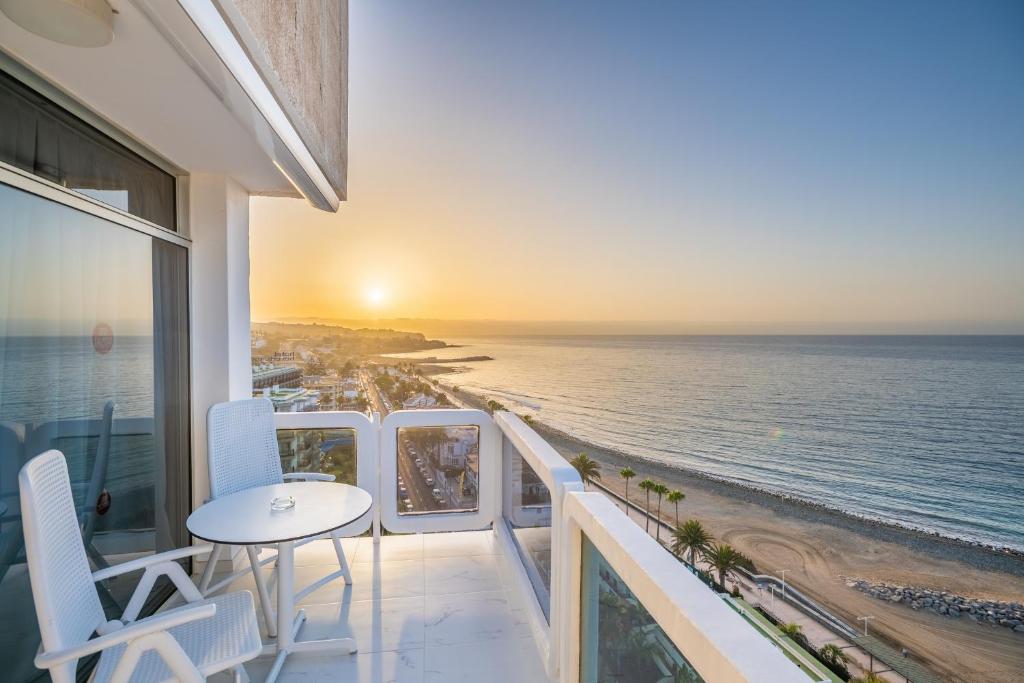 einen Balkon mit einem Tisch, Stühlen und Meerblick in der Unterkunft Hotel Europalace in Playa del Ingles