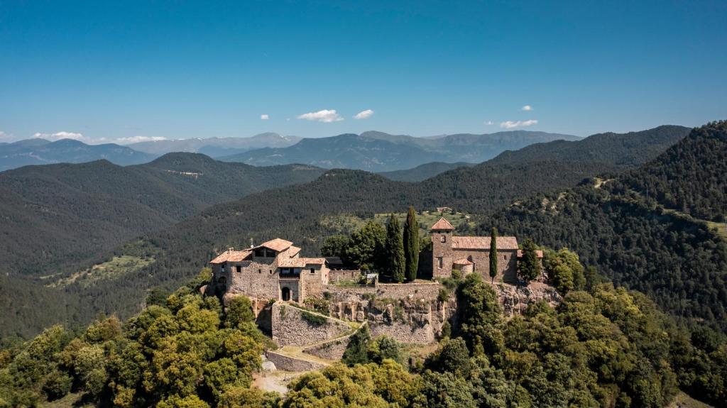 un viejo castillo en una colina en las montañas en Castell de Llaés, en Llaés