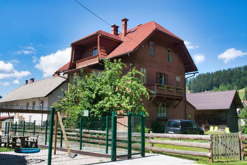 una casa con un parque infantil delante de ella en Apartma Vila Kočna, en Zgornje Jezersko