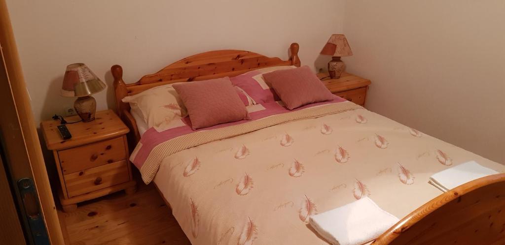 a bedroom with a bed and two night stands and two lamps at Mirni kutak in Donje Pazarište