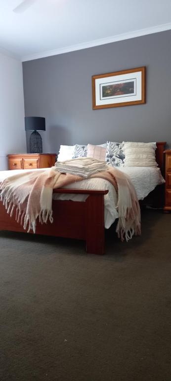 a bedroom with a large bed with a blanket at Tukawyl Retreat Landsborough in Landsborough