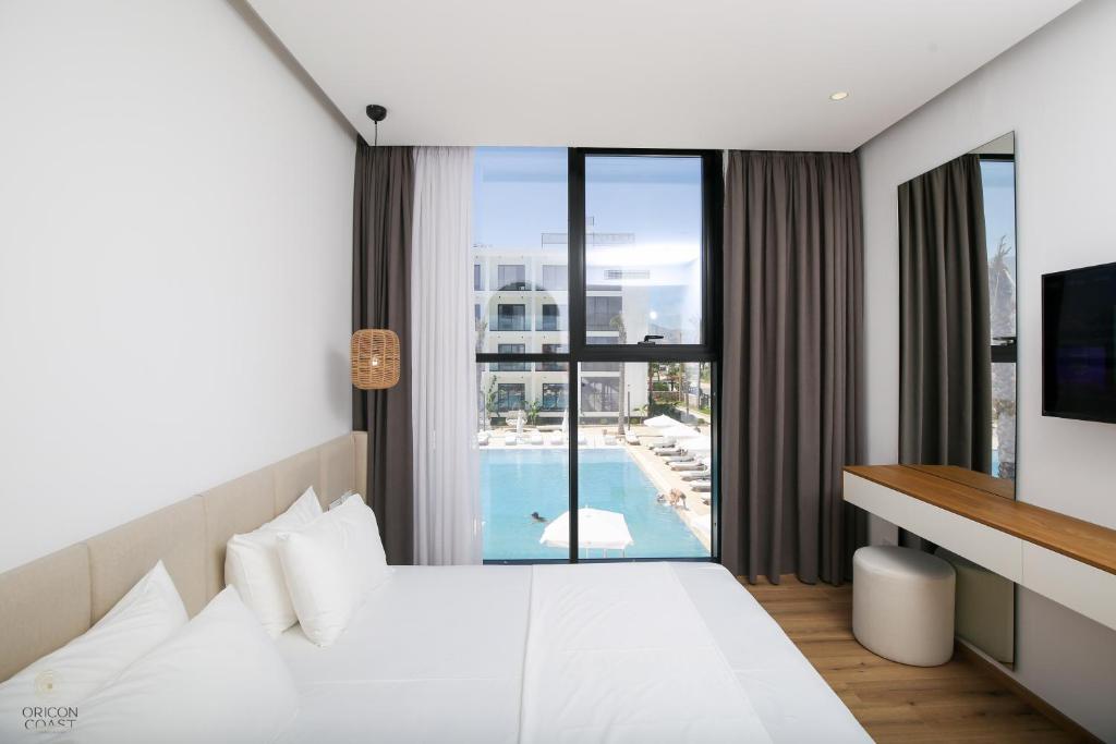 Schlafzimmer mit einem Bett und Poolblick in der Unterkunft Oricon Coast Luxury Resort in Orikum