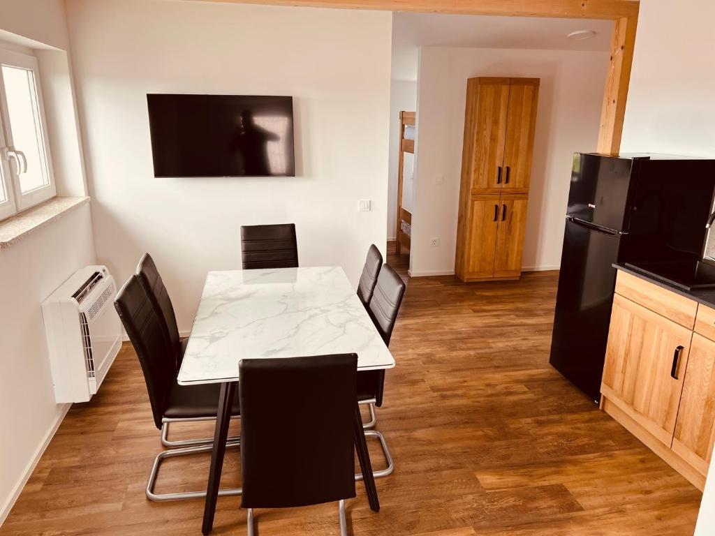a kitchen with a table and chairs and a refrigerator at PJagodic Hotel Cerklje - 5min to Airport in Cerklje na Gorenjskem