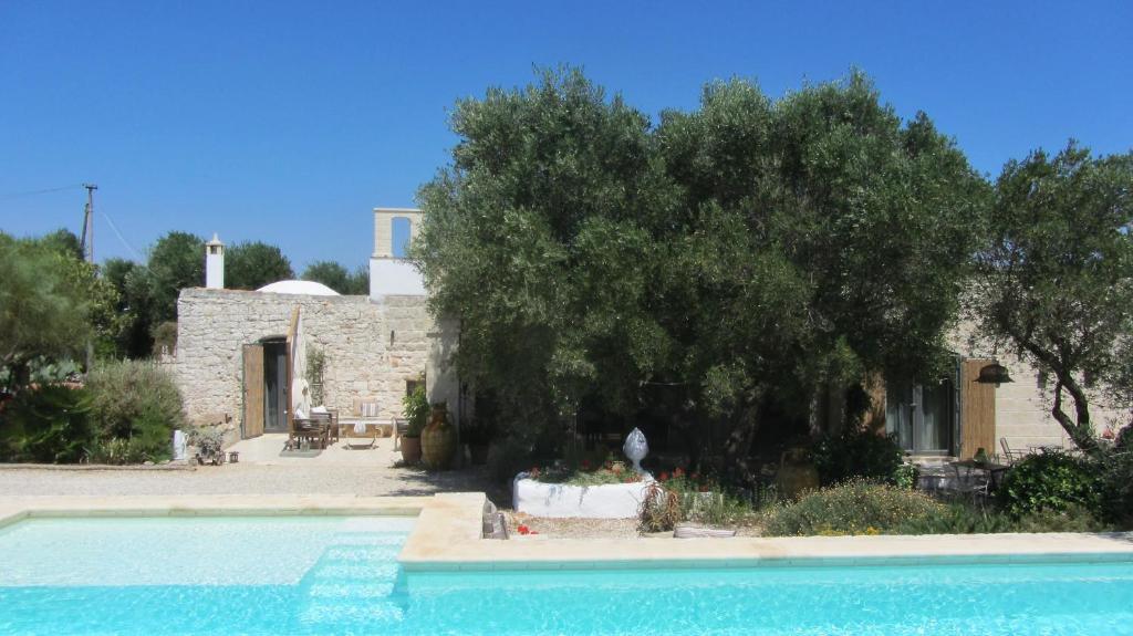 une maison avec un arbre et une piscine dans l'établissement Casa della Scrittrice, à Ostuni