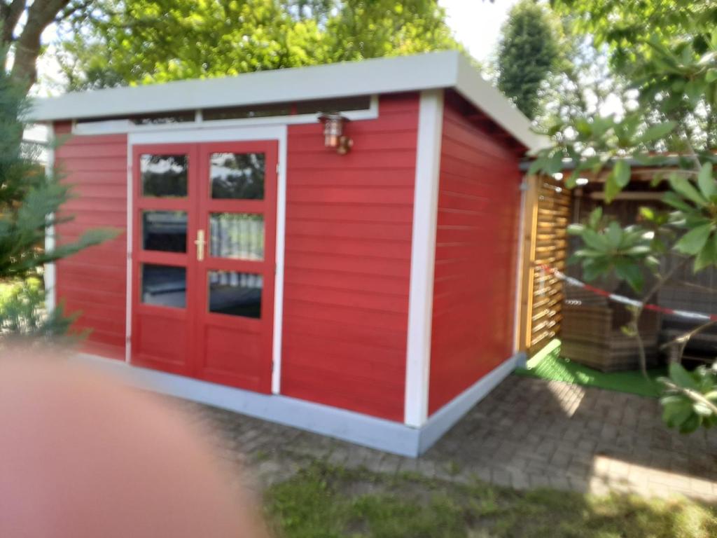 un cobertizo rojo con una puerta roja en Die Radlerhütte - NUR FÜR EINE NACHT - en Ankelohe