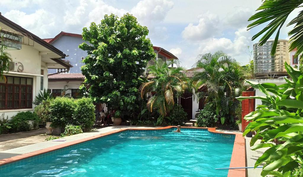 a swimming pool in front of a house at Villa Sisavad Guesthouse in Vientiane