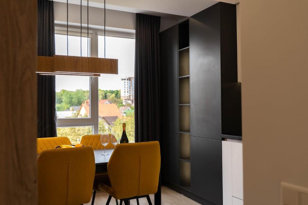 a dining room with a table and yellow chairs at RentWill apartments Yellow in Chişinău