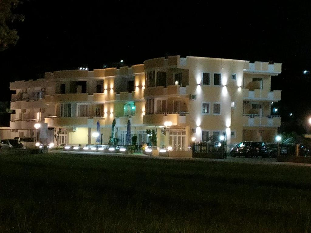un gran edificio blanco por la noche con luces en Grandino rooms&apart, en Ulcinj