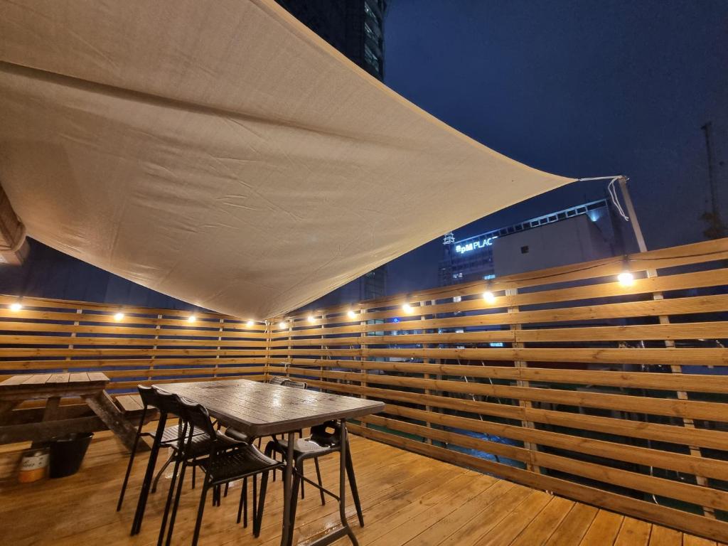 un patio con tavolo e sedie sotto una tenda. di Olive Hostel Dongdaemun a Seul