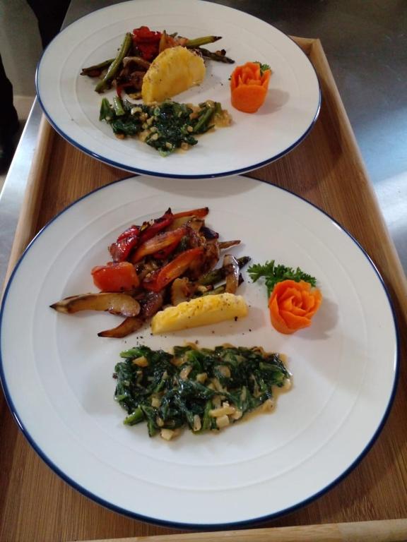 two white plates of food on a wooden table at Oruwa Boutique Villas in Arugam Bay