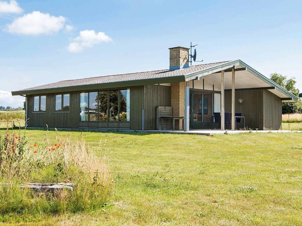 a house in a field with a grassy field at 7 person holiday home in Knebel in Knebel