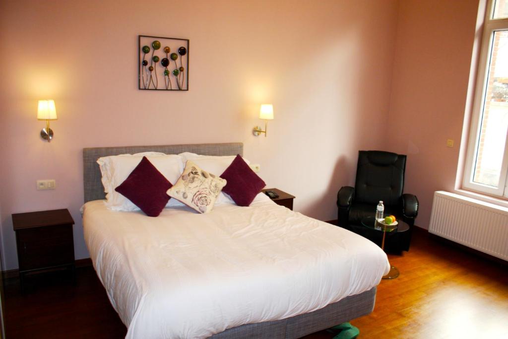 a bedroom with a bed with white sheets and pillows at EU B&B in Brussels