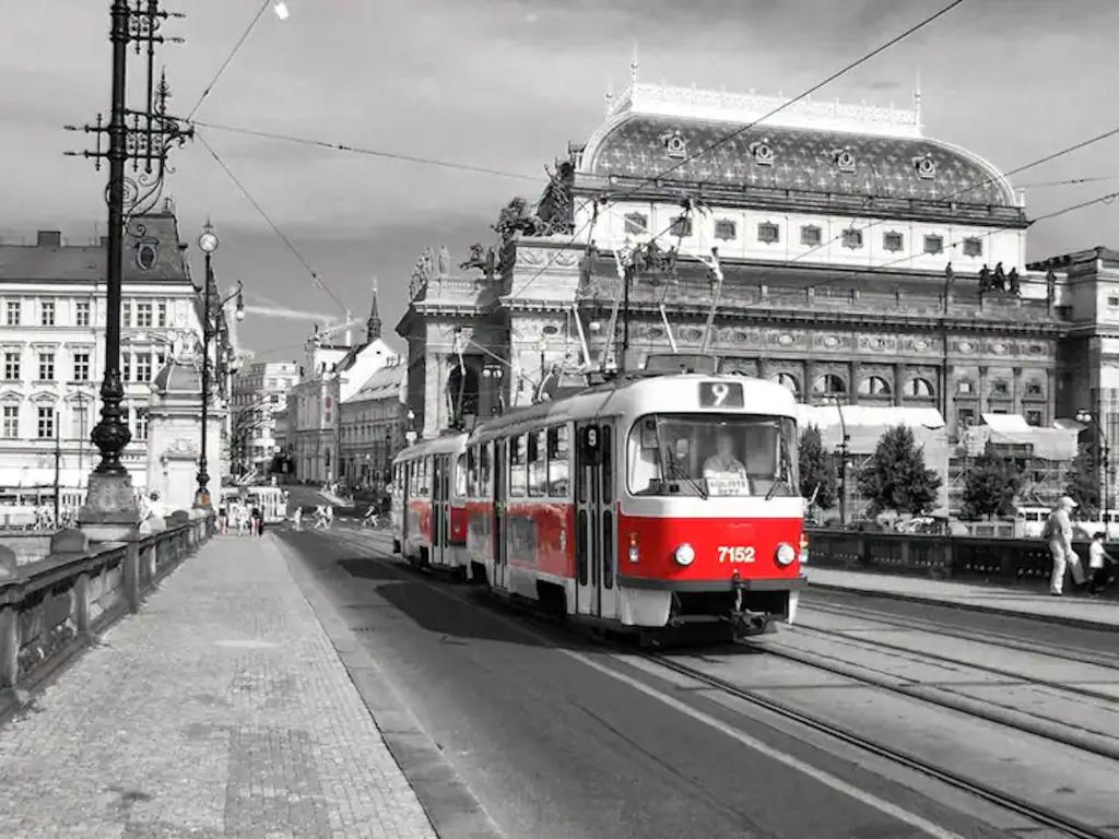 um eléctrico vermelho e branco numa rua da cidade em Ground Floor Apartment em Praga