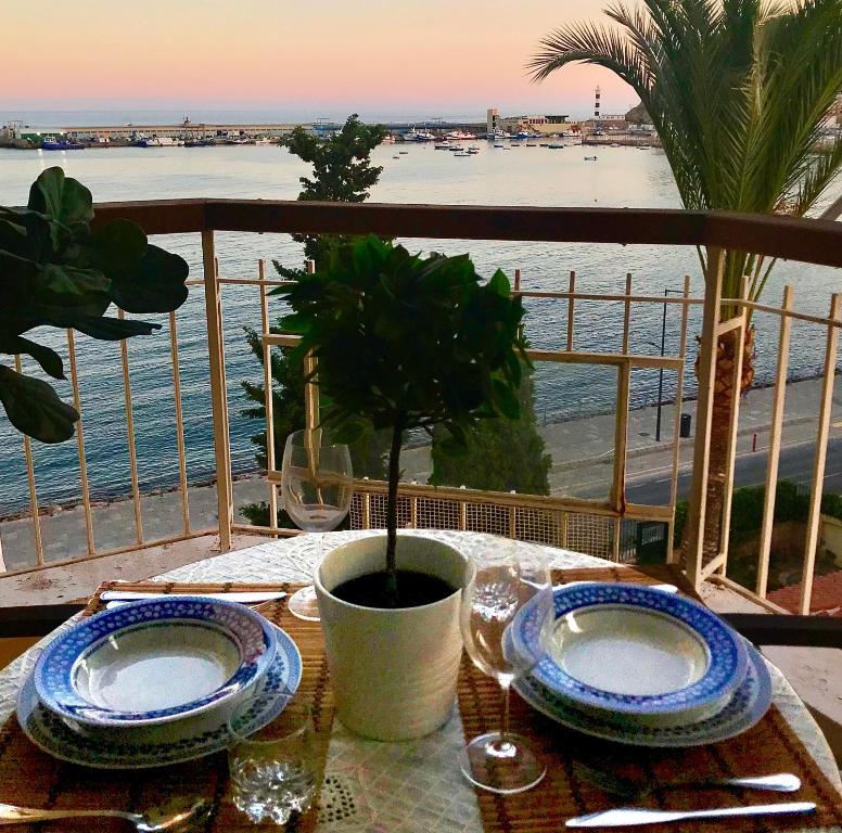 - une table avec des assiettes et une vue sur l'océan dans l'établissement Primera Linea de Playa con vistas al Mar, à Águilas