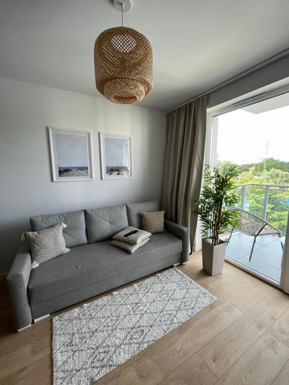 a living room with a couch and a large window at apartament Gaja in Świnoujście