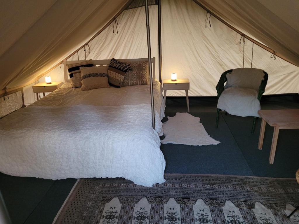 um quarto com uma cama grande numa tenda em Hideaway Glamping em Muurame