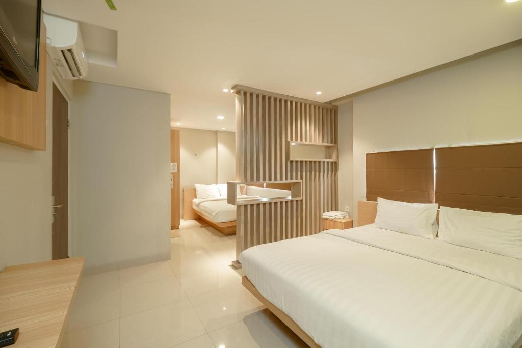 Pokój hotelowy z łóżkiem i biurkiem w obiekcie Green Apple Residence near Sarinah Mitra RedDoorz w Dżakarcie