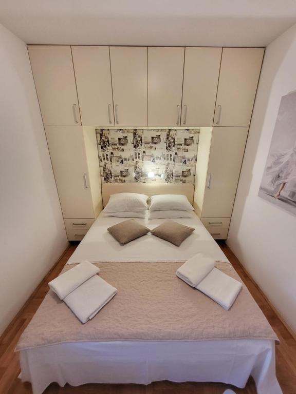 1 cama blanca grande en una habitación con armarios blancos en Apartment Rachel, en Petrovac na Moru