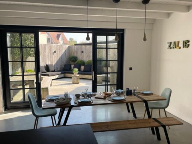 y sala de estar con mesa de comedor y sillas. en Authentiek vissershuisje Oud-Knokke, en Knokke-Heist