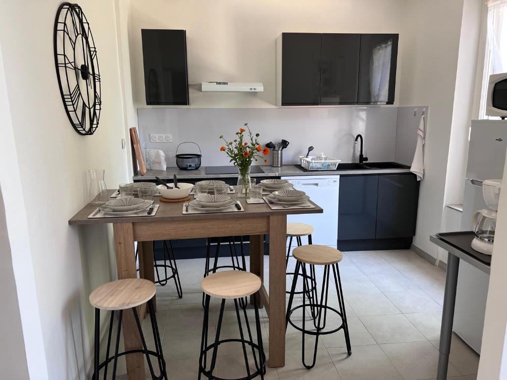 cocina con mesa y taburetes en una habitación en Charmante maison Climatisée avec piscine au Calme à Carcassonne, en Carcassonne