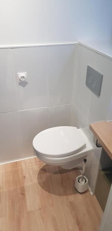a white toilet in a bathroom with a wooden floor at Escapade Niortaise - Studios climatisés hyper-centre de Niort in Niort