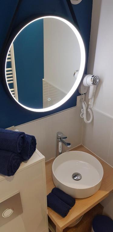 a bathroom with a white sink and a mirror at Escapade Niortaise - Studios climatisés hyper-centre de Niort in Niort