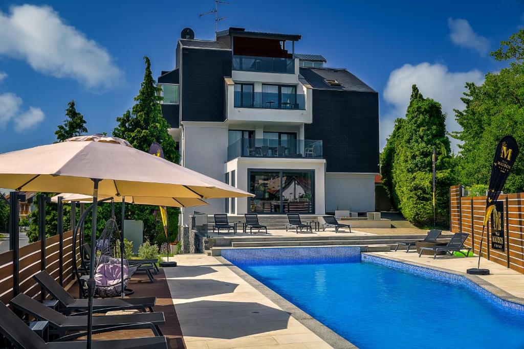 a house with a swimming pool and an umbrella at Villa Madison in Zagreb