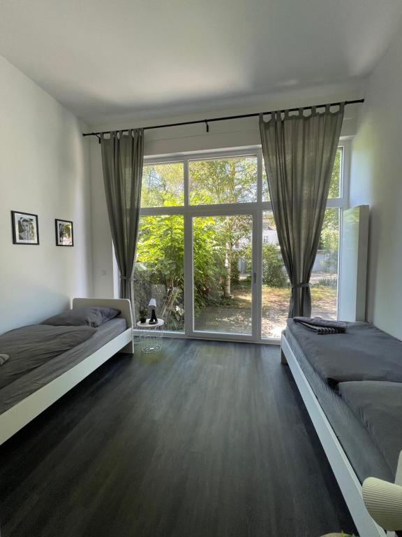 a bedroom with two beds and a large window at Herne Zentral Apartment in Herne