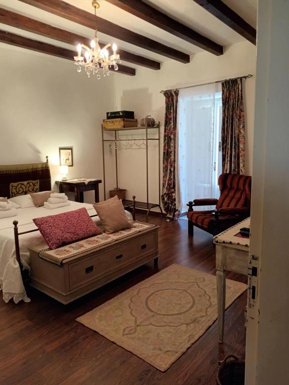 um quarto com uma cama, um sofá e um lustre em A casa del Nonno em Isnello
