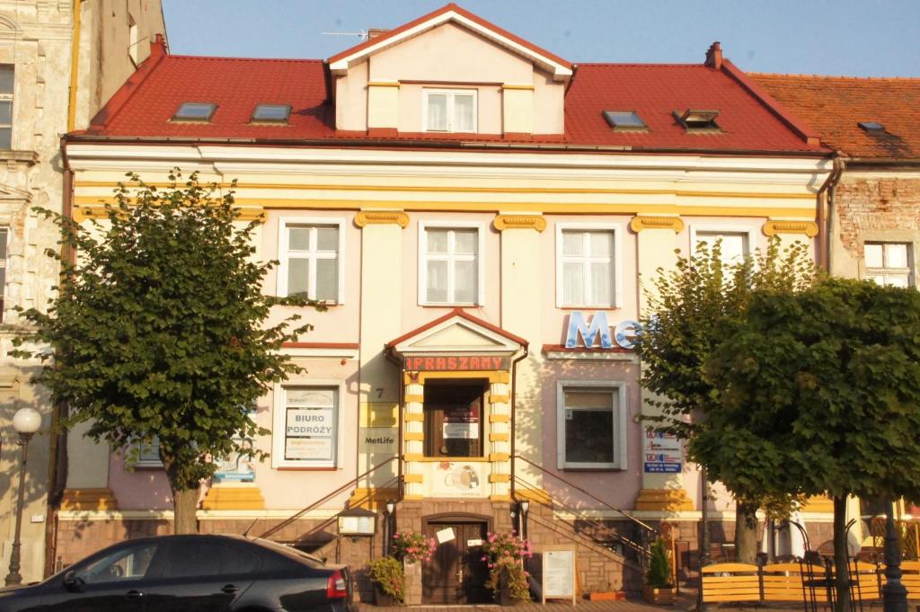コニンにあるZajazd Grodzkiの赤い屋根の大きな黄色の建物