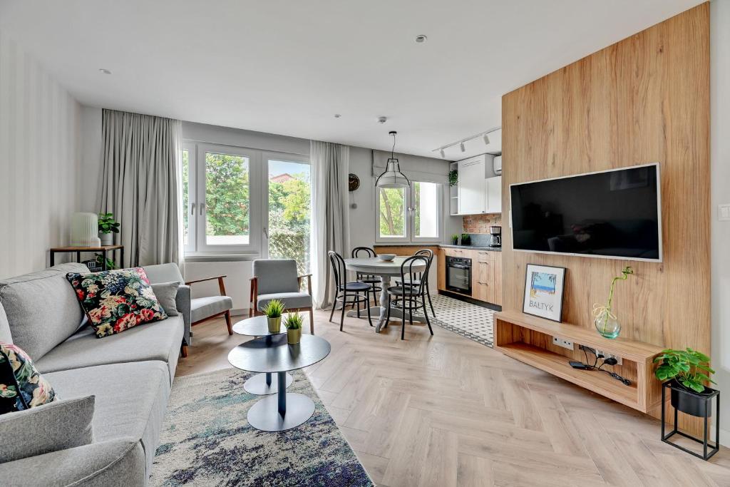 een woonkamer met een bank en een tv bij Dom & House - Apartments Old Town Podwale Staromiejskie in Gdańsk