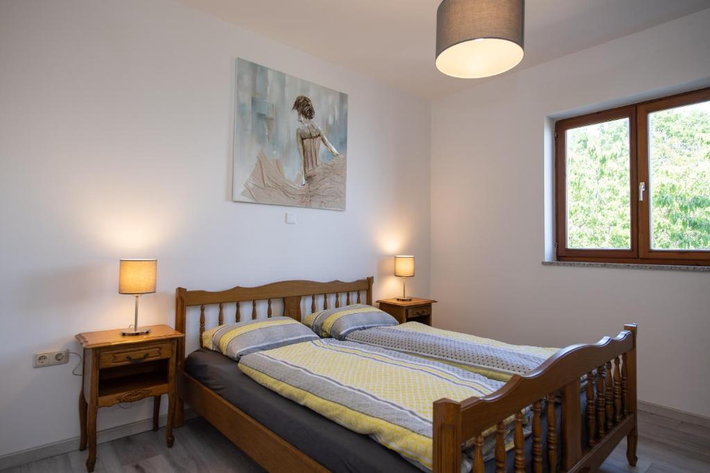 a bedroom with a wooden bed with two lamps at Bela Vista 5 Rustikales Appartement in Volosko