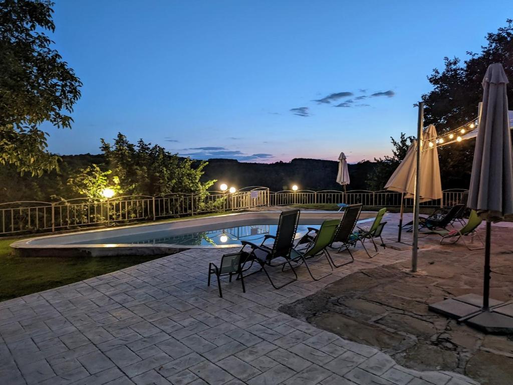 una piscina con sedie e ombrelloni di notte di Villa Girgina a Bukovets