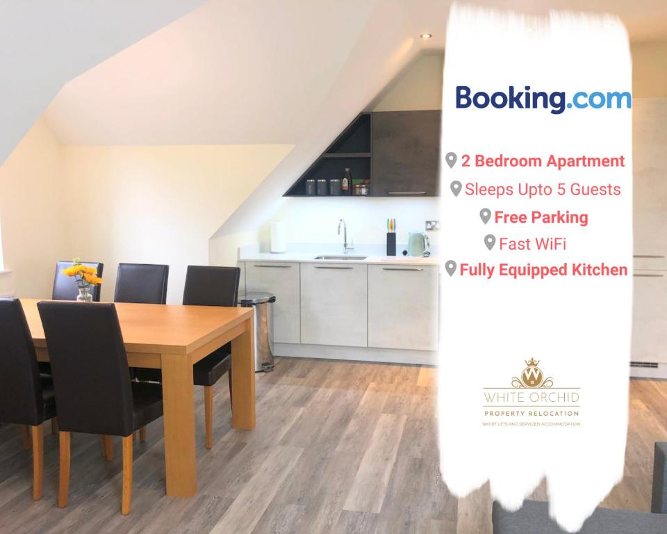 a kitchen and dining room with a wooden table and chairs at Exclusive Accommodation Free Parking AL10 Hatfield Galleria University free Wi-Fi by White Orchid Property Relocation in Hatfield