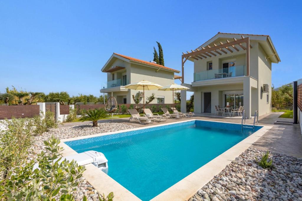 uma villa com uma piscina e uma casa em Villa Vilenia Harmony by Villa Plus em Katastárion
