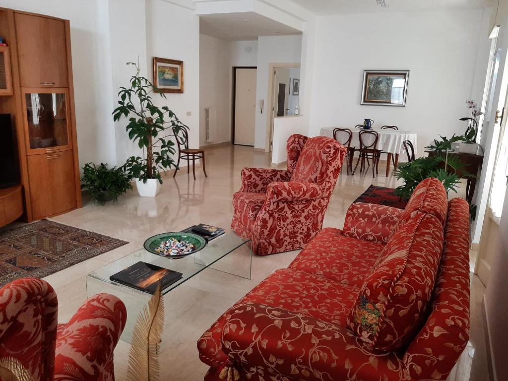 salon z czerwonymi kanapami i stołem w obiekcie interno13bari w mieście Bari