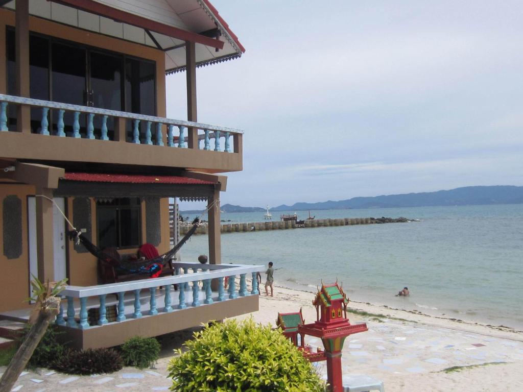 a building on the beach next to the ocean at Charung Beach in Haad Rin