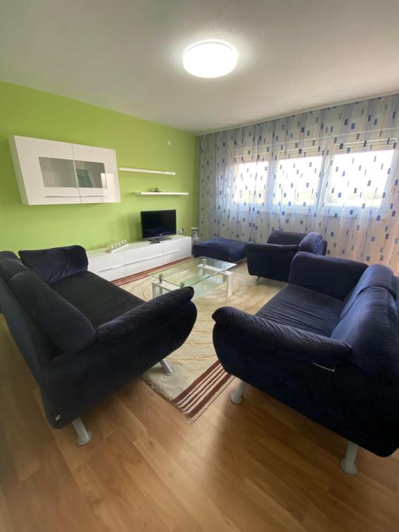 a living room with two blue couches and a tv at Apartman “IVA” in Drvar